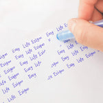 The 0.7mm blue erasable pen being used to erase some words that have been written on a paper - Stationery Island