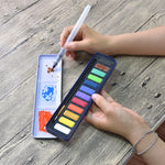 A person using the aqua brush to mix colours on the lid of the creative collection watercolour paint set that has 12 colours - Stationery Island