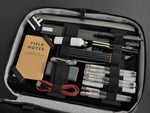 The inside space of the etchr art satchel that has been filled with pens, a phone cable and a ruler - Stationery Island 