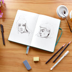 A drawing of a girl that has been done inside the black A5 blank notebook, plain journal - Stationery Island
