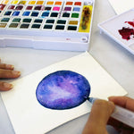 Colours from the Ezigoo watercolour paint set that has 48 colours and an aqua brush, used to paint a picture of the space galaxy - Stationery Island