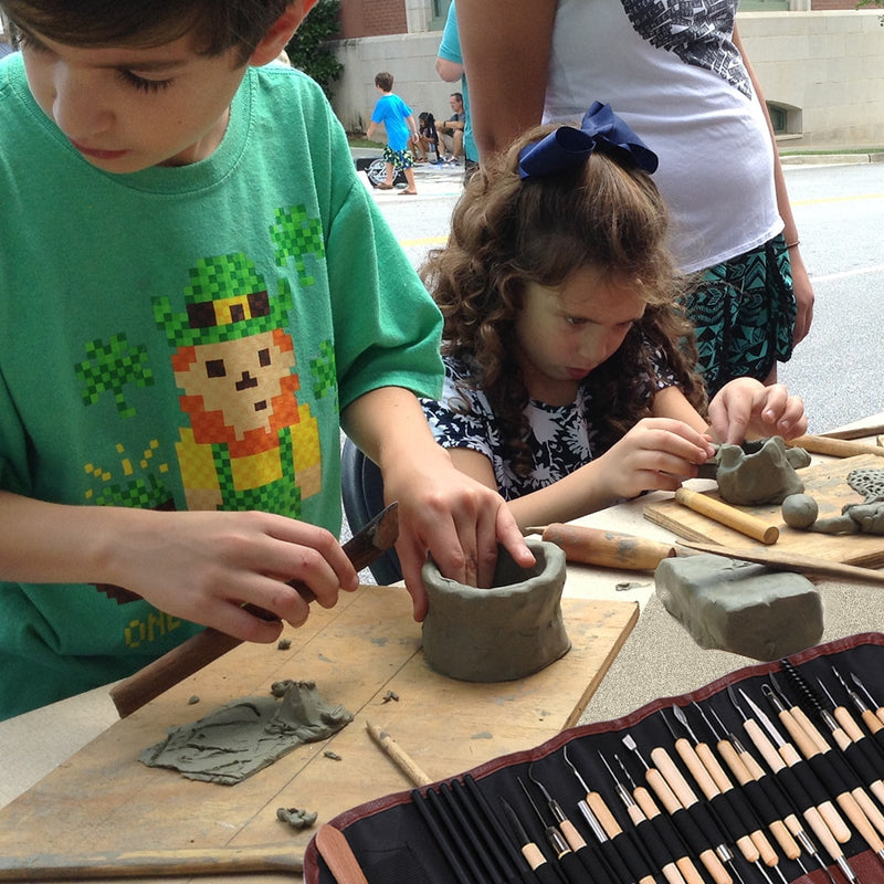 Children sculpting a clay pot - Stationery Island